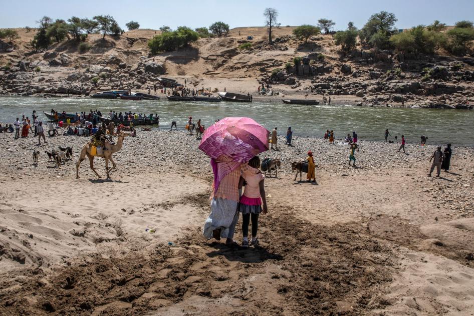 Refugees who fled the conflict in Ethiopia's Tigray region, which involved Eritrean as well as Ethiopian forces, arrive on the banks of the Tekeze River on the Sudan-Ethiopia border, November 20, 2020.