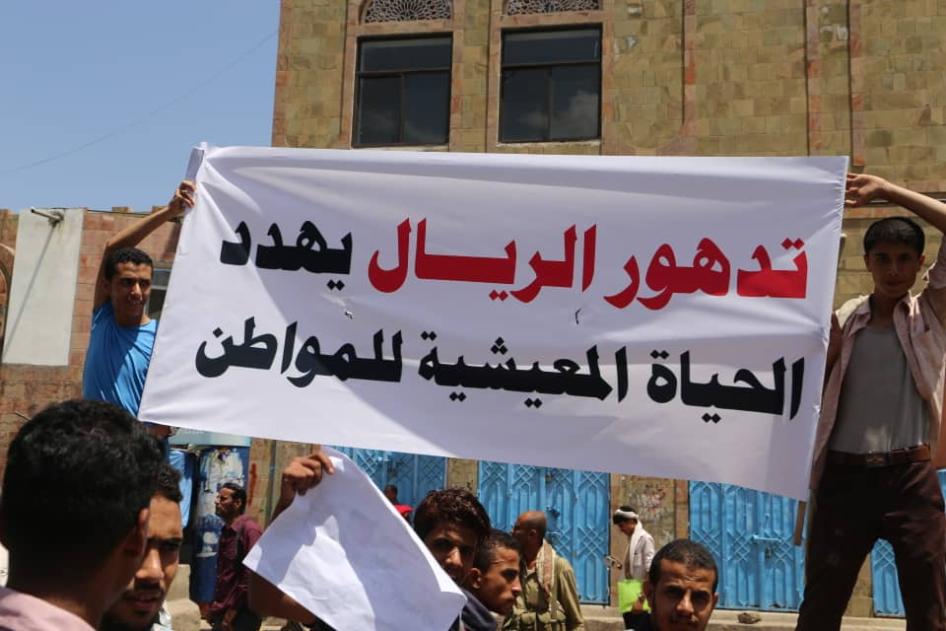Demonstrators hold a banner that reads, "the depreciation of Yemen's rial currency threatens citizens' livelihood," in Taiz, Yemen, December 2018.