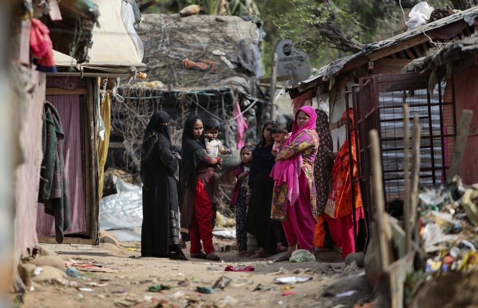 जम्मू के बाहरी इलाके में स्थित अपने अस्थायी शिविर के बाहर खड़े रोहिंग्या शरणार्थी, भारत, 7 मार्च 2021.