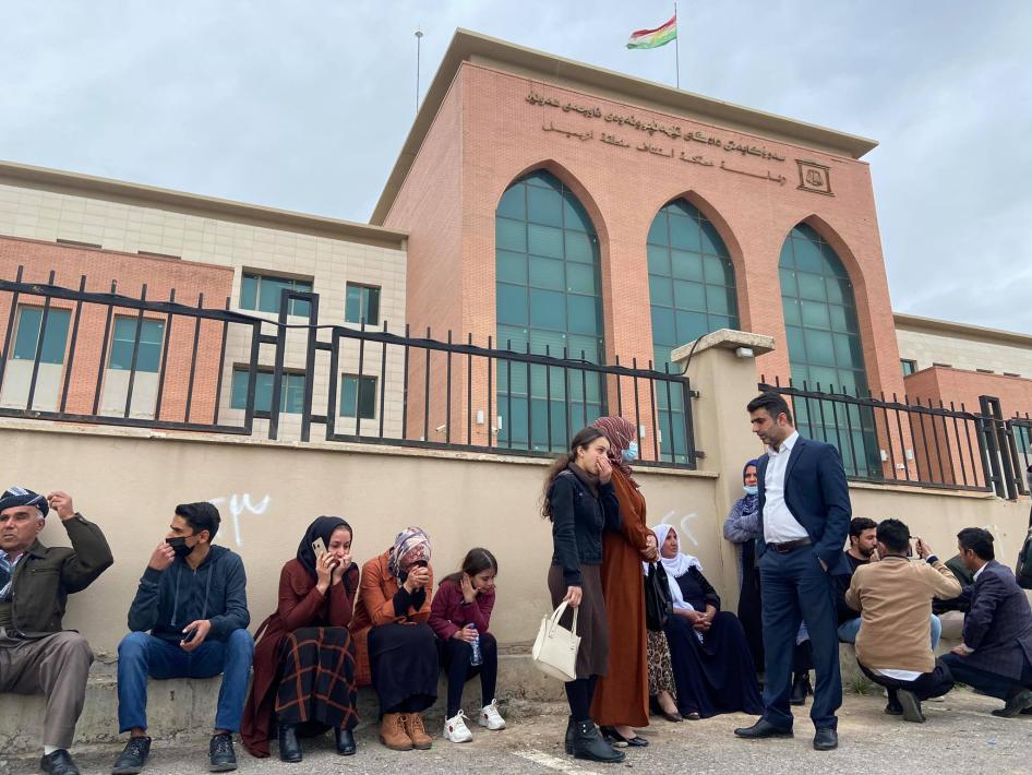 خێزانی چالاکوانان و ڕۆژنامەنوسەکان لە ڕۆژی دادگایکردنی ١٦ی شوباتی ٢٠٢١، دانیشتوون لە دەرەوەی سەرۆکایەتی داداگای تێهەڵچوونەوەی ناوچەی هەولێر.