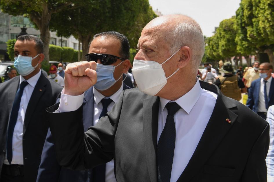 الرئيس التونسي قيس سعيّد يرفع قبضته تحية للمارة أثناء سيره في جادة الحبيب بورقيبة في العاصمة التونسية، في 1 أغسطس/آب 2021. 