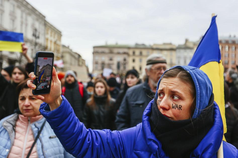 Une manifestante filme une manifestation en direct à l'aide de son smartphone à Cracovie, en Pologne