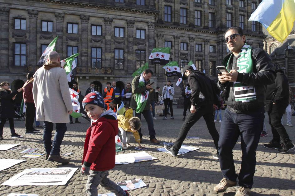 People display Syrian flags at a demonstration