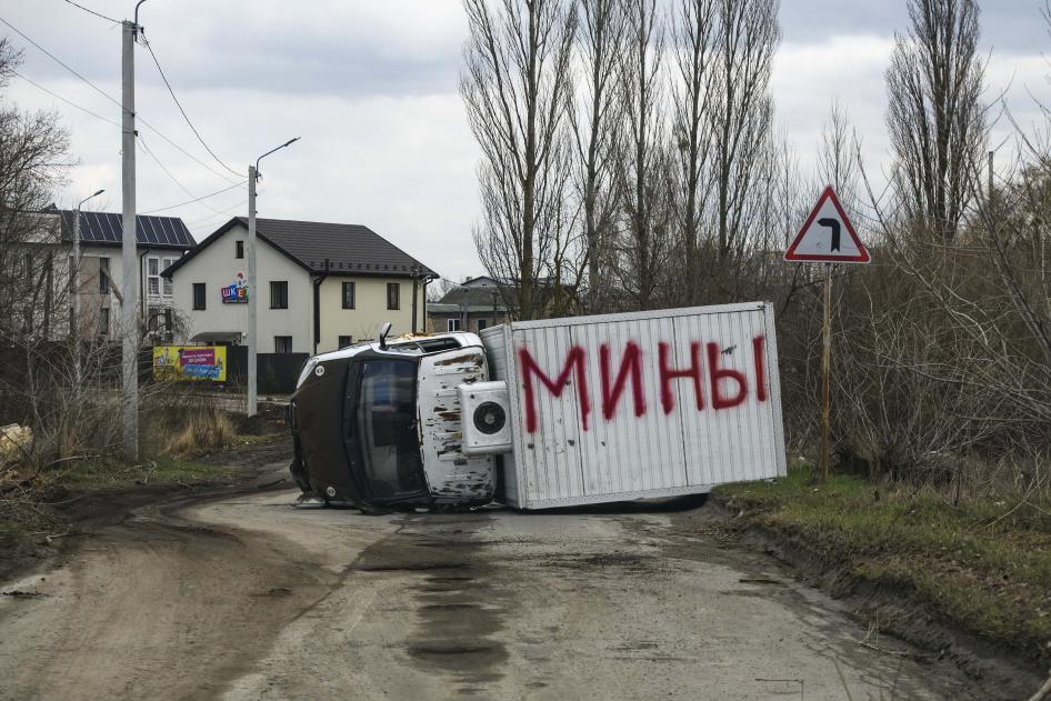 Un véhicule partiellement détruit et renversé à Boutcha, en Ukraine. Le mot "mines" en russe (мины) a été inscrit en énormes lettres rouges sur le haut du véhicule renversé. Photo prise le 4 avril 2022.