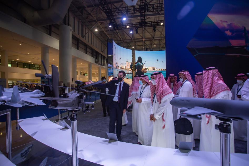 Men examine models of military equipment