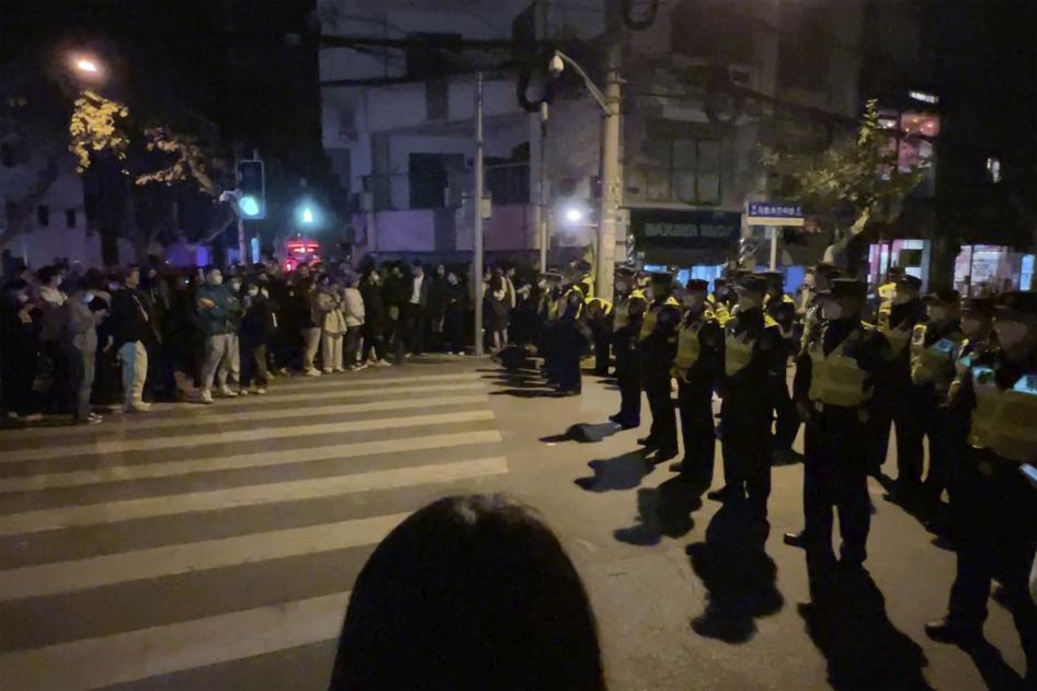 Chinese police officers block off access to a site where protesters had gathered in Shanghai on November 27, 2022.