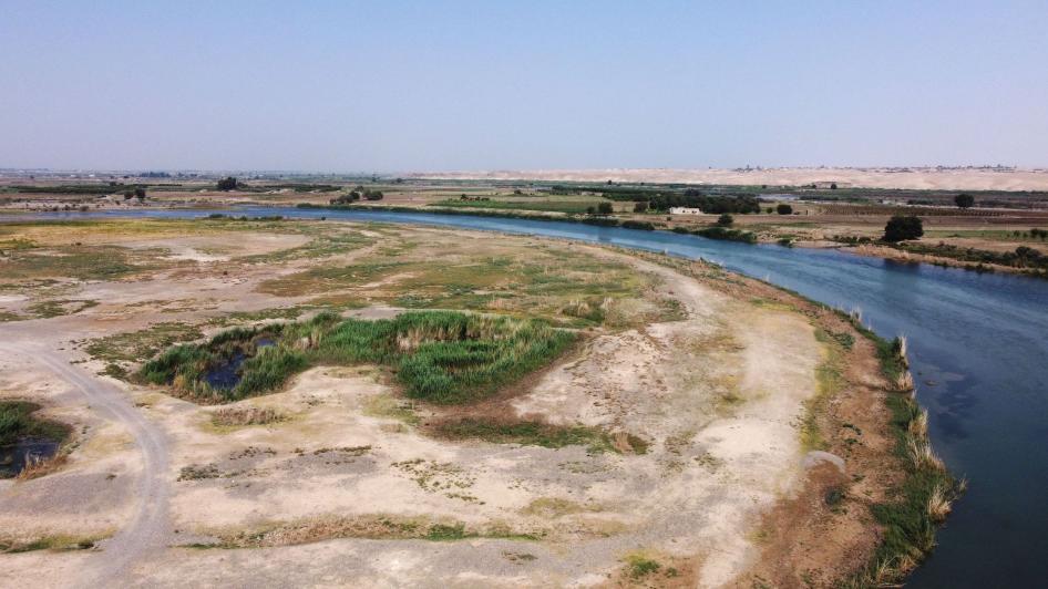 Wêneyeke asmanî ku bi dronê di 5ê Tebaxa 2022an de hatiye kişandin, dîmeneke giştî ya çemê Firatê bi asteke avê ya nizm li gundewarê rojavayê Reqayê nîşan dide di 5ê Tebaxa 2022an de. © Delil SOULEIMAN/AFP