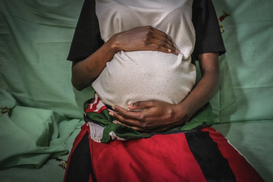 A 19-year-old mother is seen holding her baby bump in Nairobi, Kenya, July 7, 2020. 
