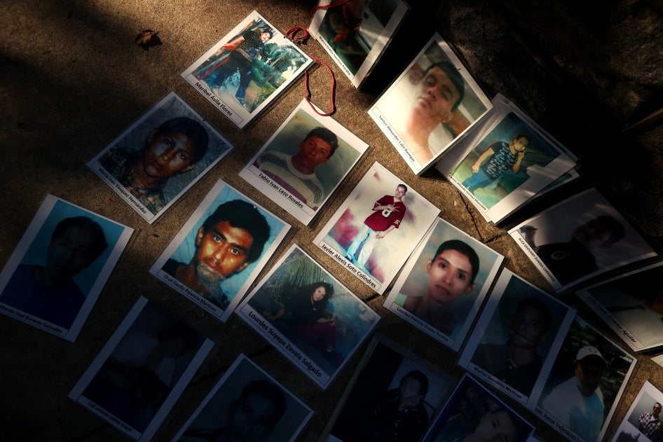 Photographs of people who disappeared while attempting to migrate to the United States are laid out across the street from the US Capitol in Washington, DC, October 19, 2021. 