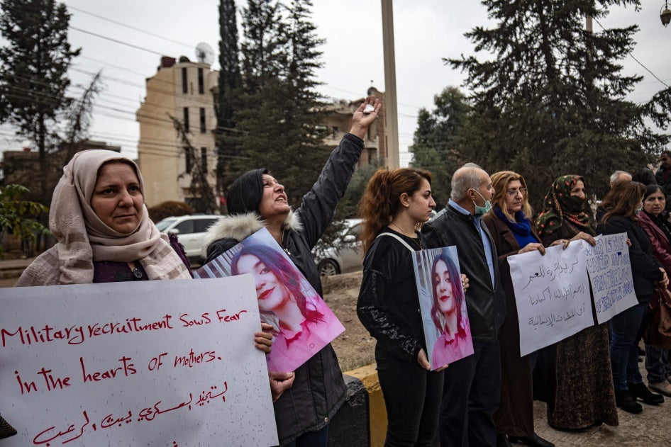 Kurdine Sûrî li derveyî avahiyeke Neteweyên Yekbûyî xwenîşandan dikin, û banga alîkariyê li desthilatdarên Kurd ê li Sûriyê dikin ji bo azadkirina keçên ku hatine revandin û tevlî şer hatine kirin, li bajarê Qamişlo yê li bakurê rojhilat, 28ê Mijdara 2021an. 