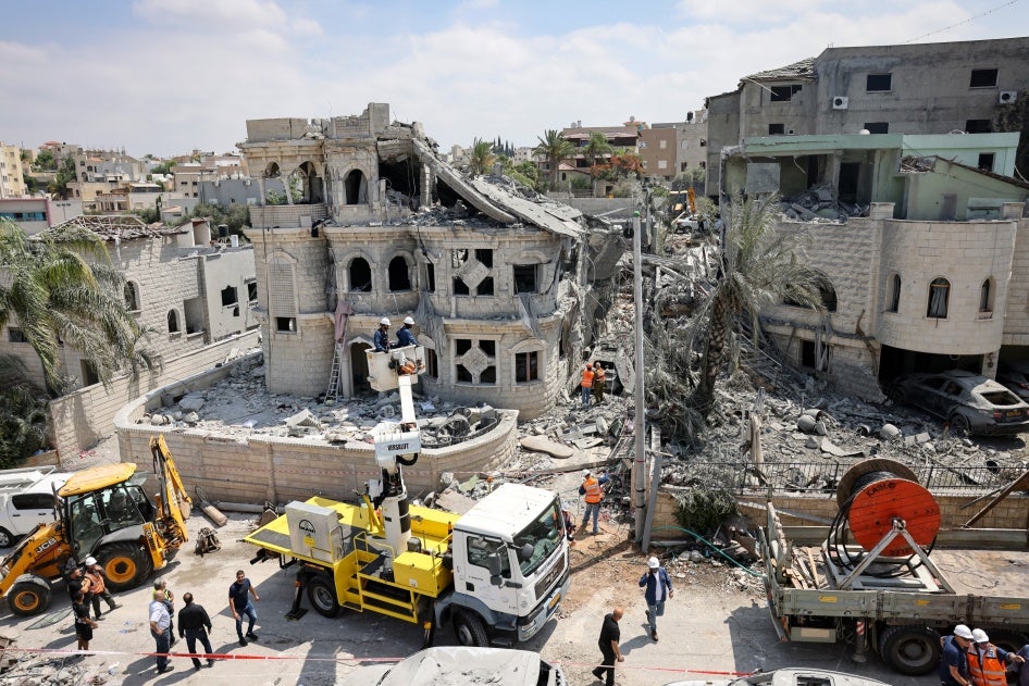 כיתוב: צוותי הצלה מפַנים הריסות בבית משפחת חטיב, שארבע מבנותיה נהרגו בתקיפת טילים איראניים בשעת לילה על העיר הפלסטינית טמרה שבצפון ישראל ב-14 ביוני 2025 