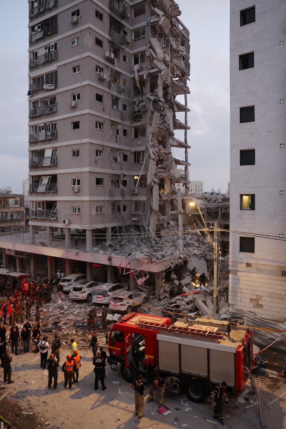 כיתוב: צוותי חירום והצלה פועלים בתוך הריסות בניין לאחר פגיעה של טיל איראני בבת ים ב-15 ביוני 2025. בפגיעה נהרגו תשעה אזרחים, בהם שלושה ילדים 