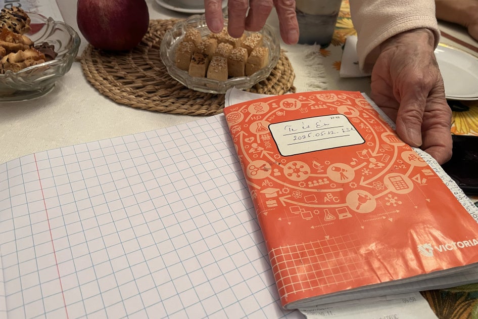Anna, une femme hongroise âgée de 80 ans, montrait un carnet contenant des relevés détaillés des dépenses mensuelles effectuées sa sœur Erika, 84 ans, et elle-même, dans leur domicile à Budapest, en octobre 2025. 