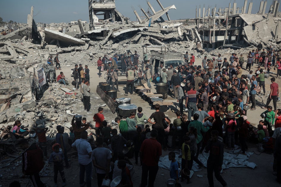 Des Palestiniens se pressent sur un site où une organisation caritative distribue de la nourriture chaude, alors que persiste une grave pénurie alimentaire, à Beit Lahia, dans la bande de Gaza, le 28 octobre 2025. 