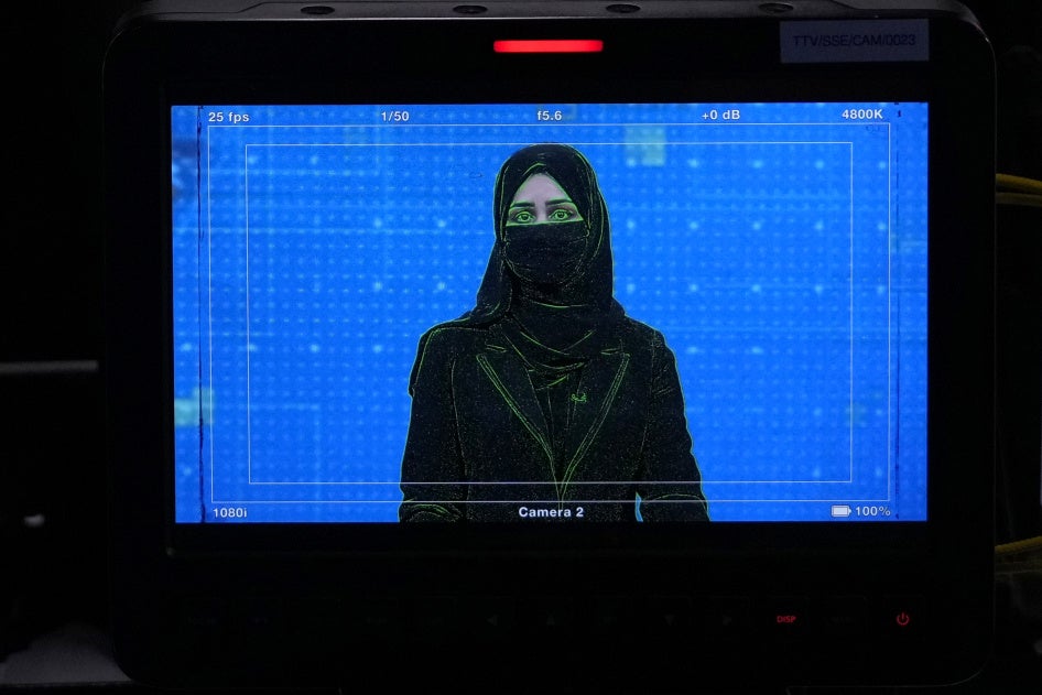 La présentatrice de télévision Khatereh Ahmadi, portant un voile qui lui couvre le visage, lit les informations à Kaboul, en Afghanistan, le 22 mai 2022.