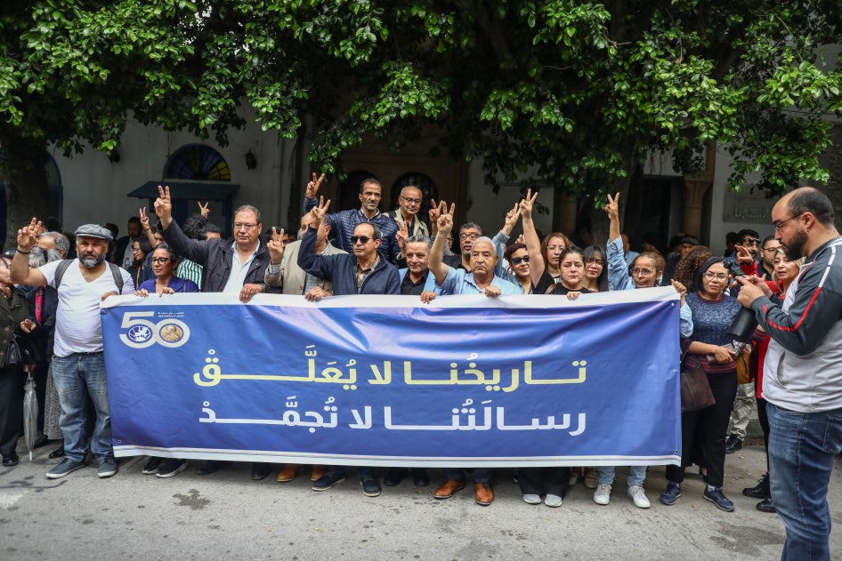 متظاهرون يرفعون لافتة باللغة كُتب عليها: "تاريخنا لا يُعلَّق، رسالتنا لا تُجمَّد"، خلال مظاهرة نُظمت عقب قيام السلطات التونسية بتعليق نشاط "الرابطة التونسية للدفاع لحقوق الإنسان"، أمام محكمة ابتدائية في تونس العاصمة، في 6 مايو/أيار 2026.