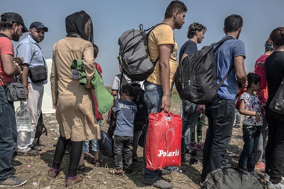 Des réfugiés et demandeurs d'asile étrangers ayant traversé la frontière serbo-hongroise font la queue afin d’être enregistrés dans le camp de transit de Röszke, près de la ville de Szeged dans le sud de la Hongrie, le 1er septembre 2015.
