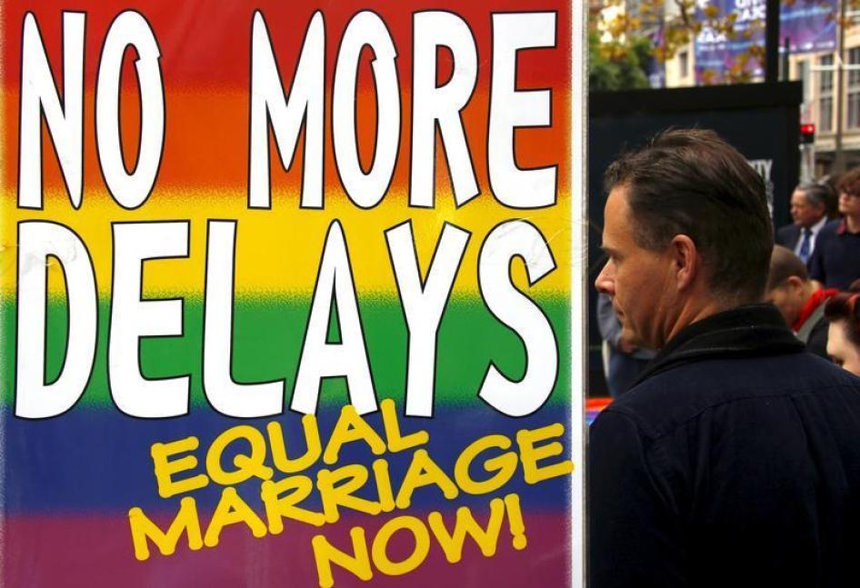 Activists stand next to a banner as they listen to speeches during a rally supporting same-sex marriage in Sydney, Australia May 31, 2015. 