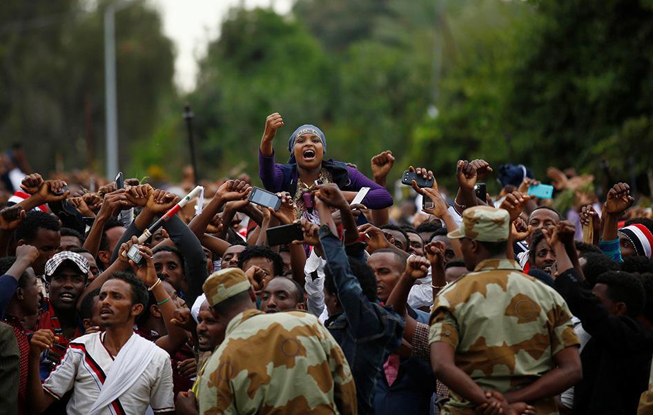 Demonstrators chant slogans while flashing the protest gesture during Irreecha, the thanksgiving festival of the Oromo people, in Bishoftu town, Oromia region, Ethiopia, on October 2, 2016.