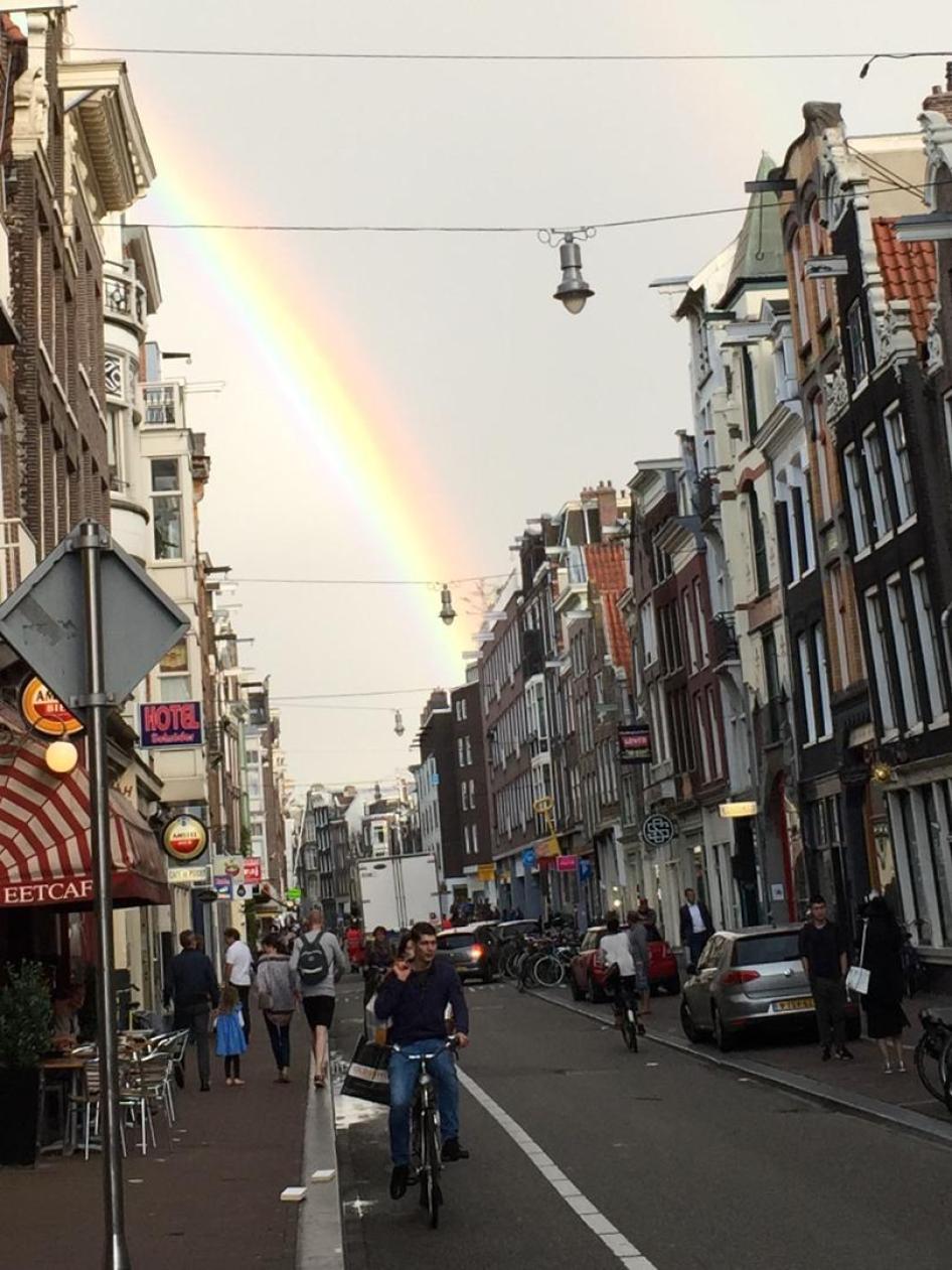 A rainbow over a typical Dutch shopping street in Amsterdam. 