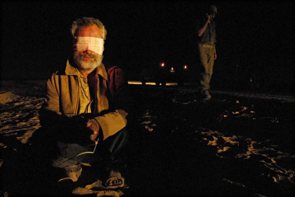رجل فلسطيني معصوب العينين، اعتقل أثناء عملية عسكرية إسرائيلية في غزة، يجلس على الأرض قرب معبر بين إسرائيل وقطاع غزة، 7 نوفمبر/ تشرين الثاني 2007.