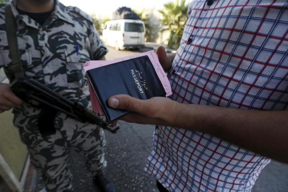 A General Security officer stands by as a Syrian bus driver carries the passports and departure cards of Syrians arriving in Lebanon. 