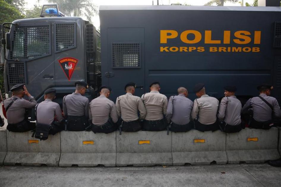 Police officers sit outside a court in Jakarta, Indonesia May 9, 2017.
