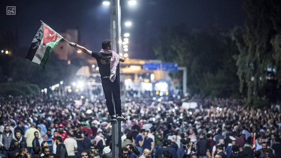 Un homme brandit un drapeau jordanien lors d’une manifestation massive contre les hausses de prix et d’impôts, près du bâtiment où est situé le bureau du Premier ministre à Amman, en Jordanie, en juin 2018.