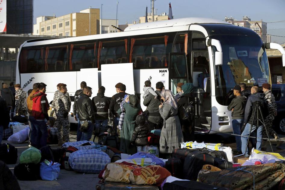 عناصر من المديرية العامة للأمن العام في لبنان يشرفون على لاجئين سوريين يستقلون حافلة ستنقلهم إلى ديارهم في سوريا. برج حمود، ضاحية بيروت الشمالية، لبنان، الخميس في 24 يناير/كانون الثاني 2019.