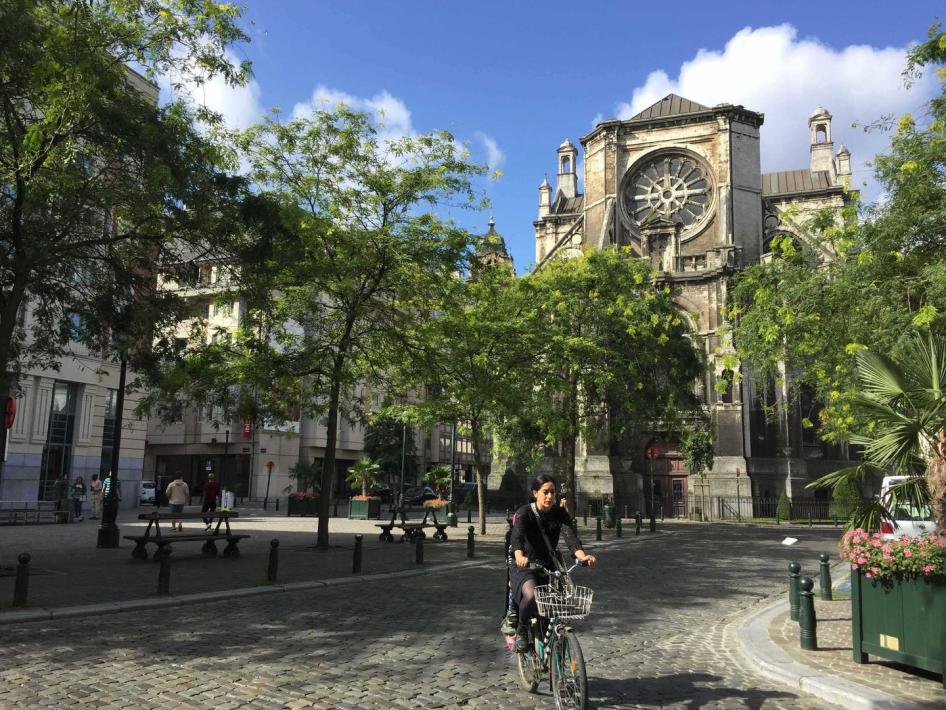 A woman riding a bike in a street on a sunny day