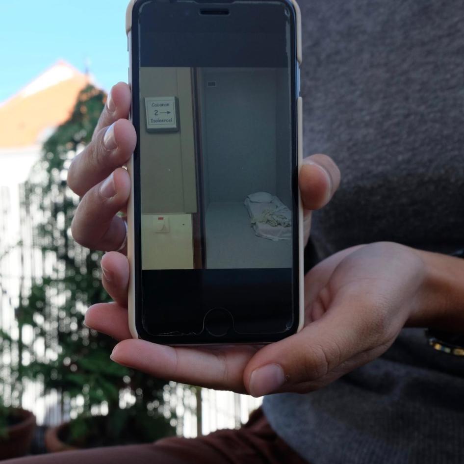 A phone displaying a photo of an isolation room