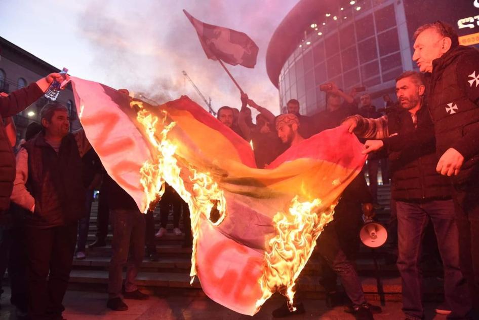 ფოტო: დემონსტრანტები თბილისში ლგბტ დროშას წვავენ ფილმის „და ჩვენ ვიცეკვეთ“ პრემიერის წინ. 