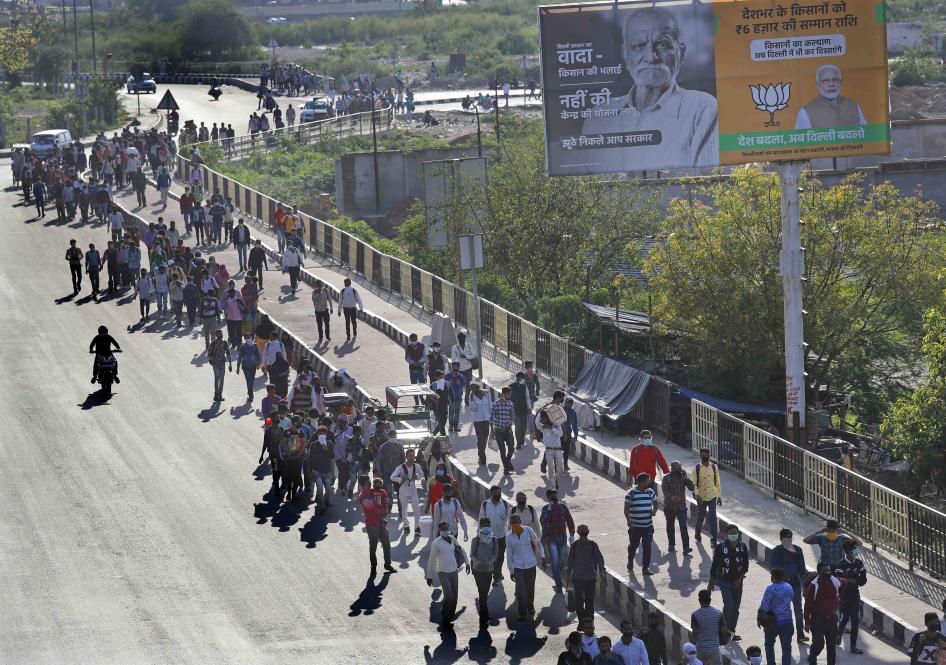 Des travailleurs migrants qui se trouvaient à New Delhi entament une longue marche pour retourner dans leurs villages le 27 mars 2020, suite à l’annonce du décret de confinement général en Inde, et à la forte réduction des services de transport public. 