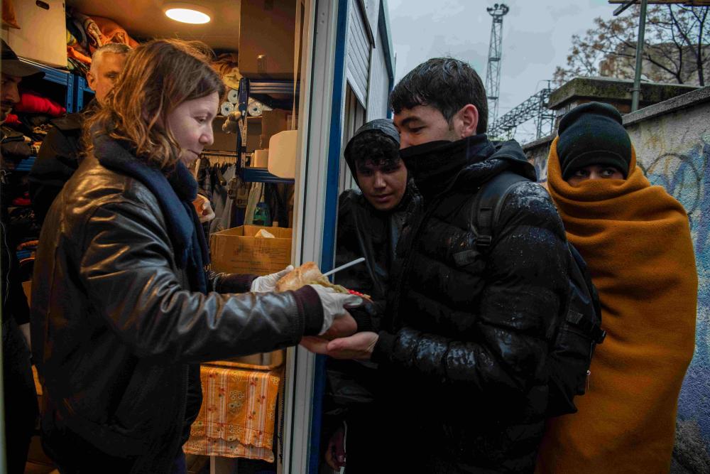 Voluntarios que colaboran con Cáritas y el Servicio Jesuita a Refugiados dan el almuerzo a solicitantes de asilo y migrantes en la estación de ferrocarril de Rijeka, Croacia.