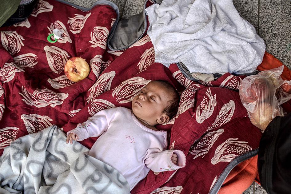 A Syrian baby sleeps on the floor inside the Keleti train station in Budapest, Hungary on August 31, 2015. 