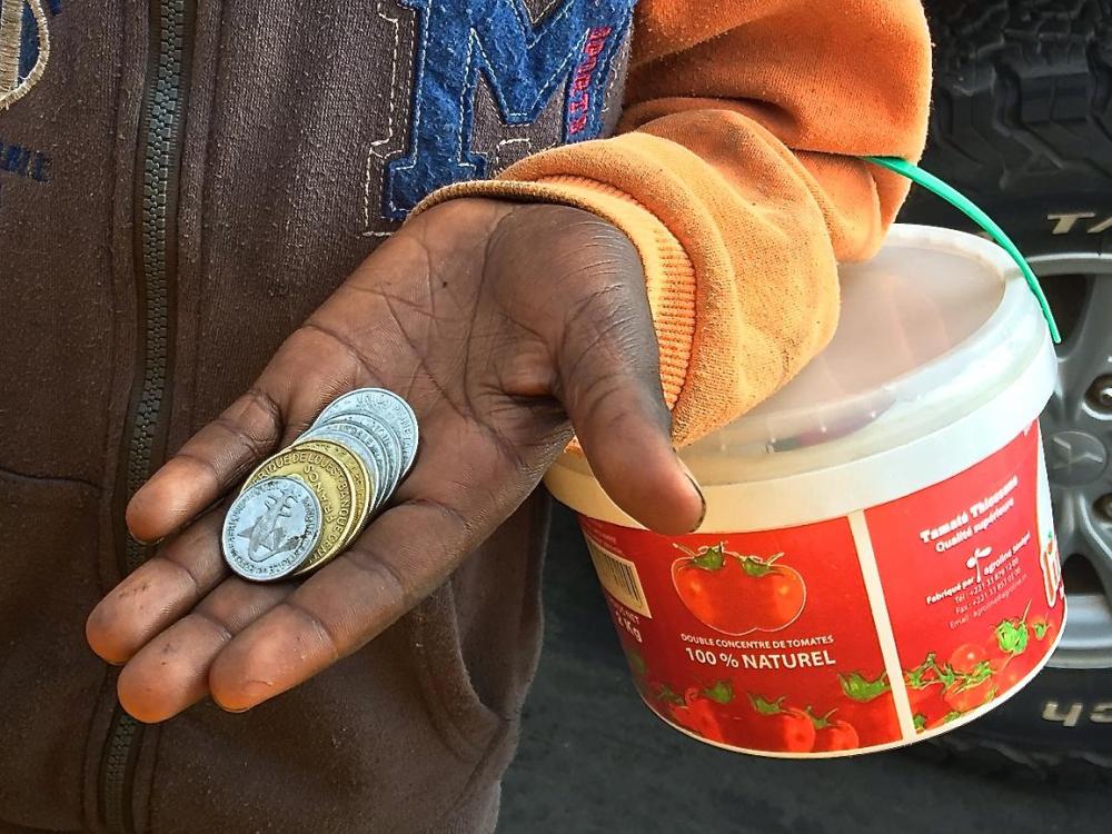 Un enfant talibé mendie à la portière d’une voiture à Dakar, au Sénégal, le 19 juin 2018. De nombreux talibés ont déclaré à Human Rights Watch que leur maître coranique leur ordonnait de revenir chaque jour avec un montant spécifique. 
