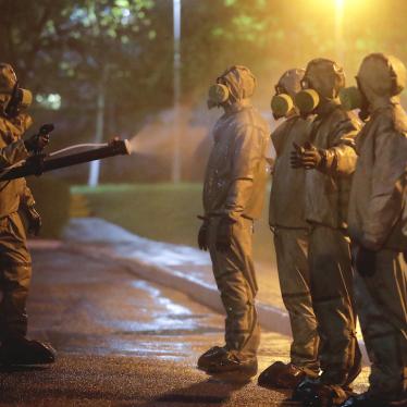 Servicemen of Belarus Ministry of Defence wearing protective gear spray disinfectant on each other after disinfecting a hospital in Minsk