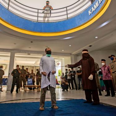 A Shariah law official uses a rattan cane to whip one of two men convicted of gay sex in Banda Aceh, Aceh province, Indonesia, January 28, 2021. 