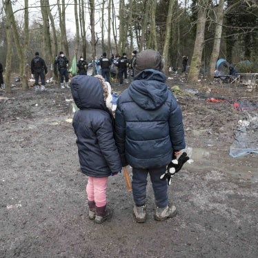 Deux enfants regardent la police saisir leur tente durant l’expulsion d’un campement à Grande-Synthe, dans le nord de la France, le 21 janvier 2021.