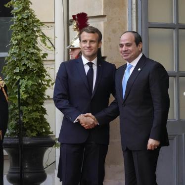 Two men in suits shake hands and pose for a photo