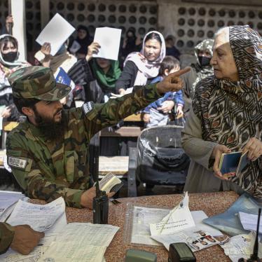 A man in military uniform points in the face of a woman 