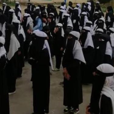 Girls stand outside while attending school