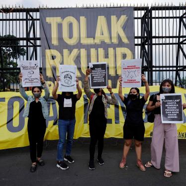 Protesters hold up signs outside parliament in Jakarta