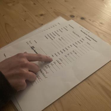 A woman calculates expenses on a sheet of paper
