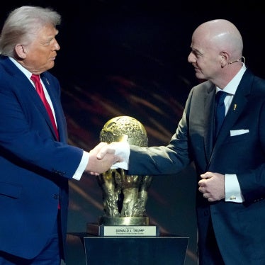 Gianni Infantino shakes Donald Trump's hand in front of the peace prize cup