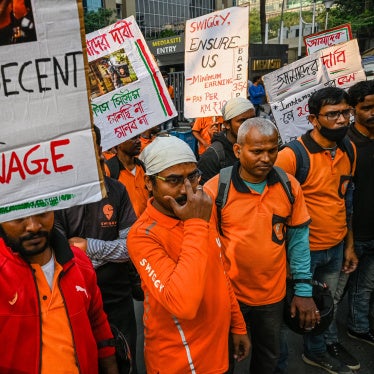 Delivery workers of an Indian food-delivery startup hold placards during a demonstration demanding a hike in their remuneration, in Kolkata, on November 22, 2022.
