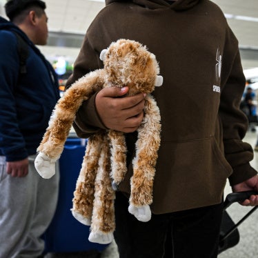 A child from Guatemala holds his stuffed monkey as he waits inside Miami International Airport to leave the United States and reunite with his recently deported parents in Guatemala, in Miami, Florida, December 4, 2025.