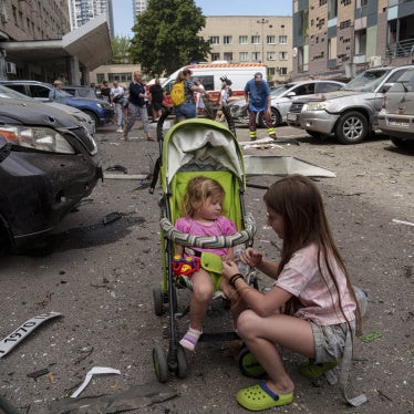 Children wait near the site of Okhmatdyt children’s hospital hit by Russian missiles, in Kyiv, Ukraine, Monday, July 8, 2024.