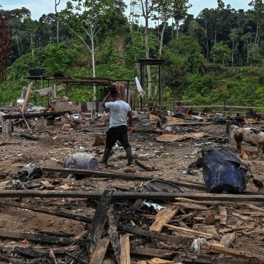 A farmer walks amidst rubble
