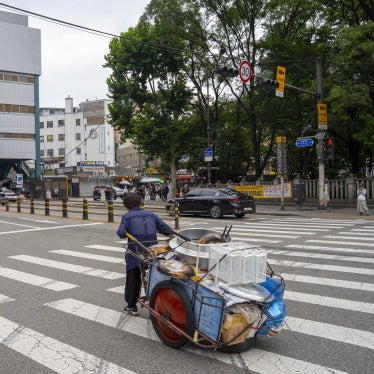 An elderly person pushing a handcart containing fast food supplies in Seoul, South Korea, August 1, 2025.